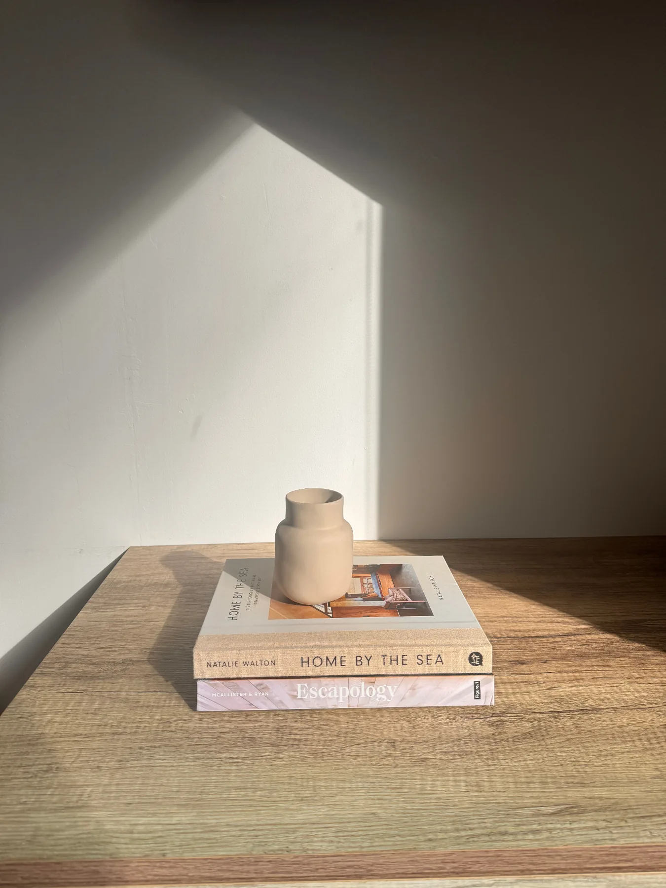 Books and a ceramic vase in the afternoon light